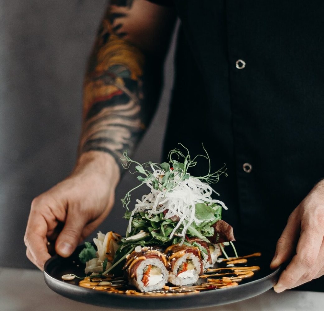 person-holding-a-plate-of-sushi-rolls-3304057.jpg